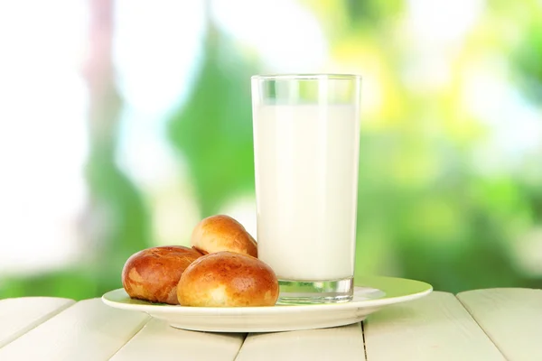 面包卷和牛奶自然背景上的木桌上的玻璃 — 图库照片