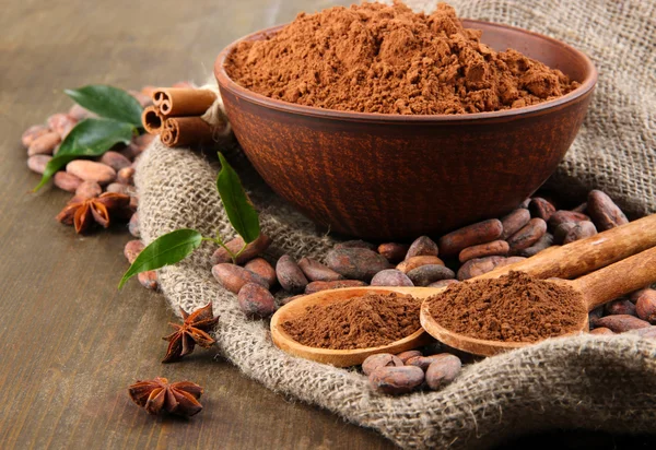 Kakaopulver und Kakaobohnen auf Holzgrund — Stockfoto