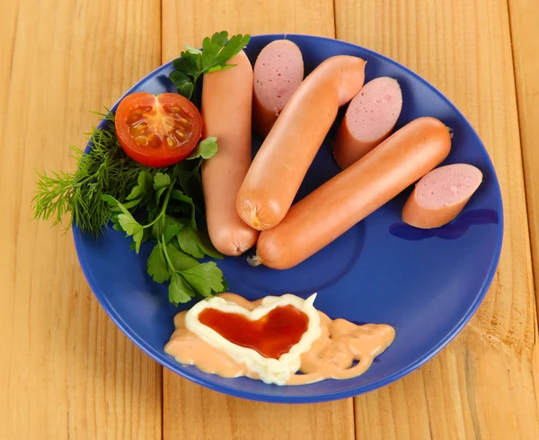 Saucisse, légumes verts, tomate sur table en bois — Photo