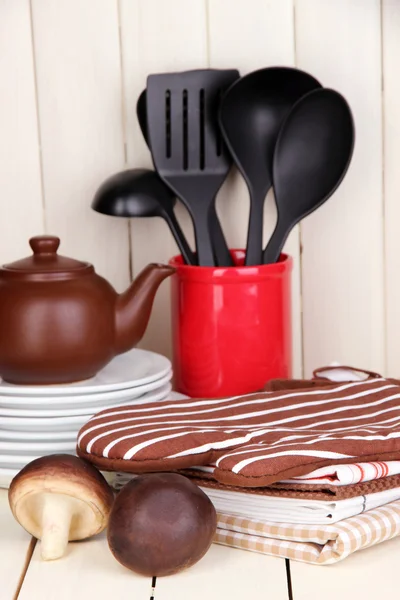 Configurações da cozinha: utensílio, pegadores de panela, toalhas e muito mais na mesa de madeira — Fotografia de Stock