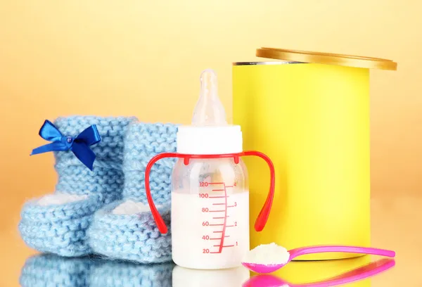 Bottle with milk and food for babies on beige background — Stock Photo, Image