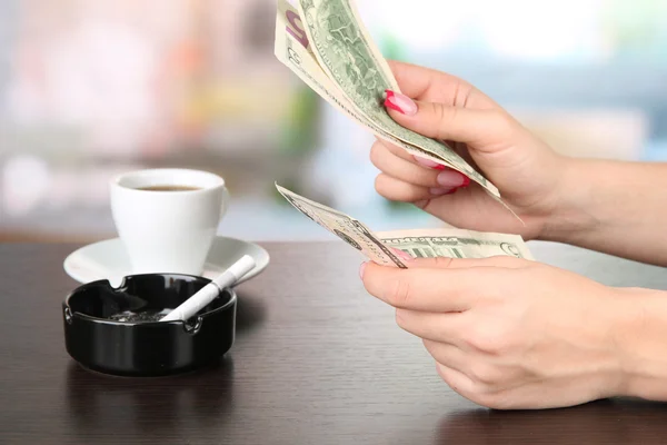 Женские руки с деньгами, на ярком фоне — стоковое фото
