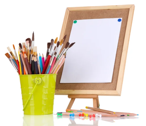 Small easel with sheet of paper with art supplies isolated on white — Zdjęcie stockowe