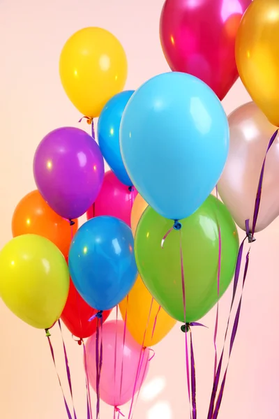 Viele helle Luftballons auf orangefarbenem Hintergrund — Stockfoto