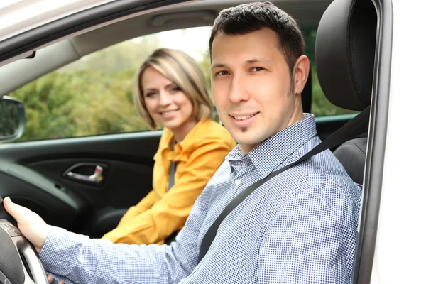 Portrait of young beautiful couple sitting in the car — Stock Photo, Image