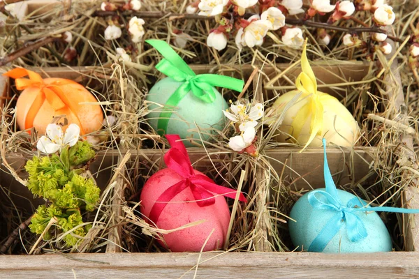 Easter eggs in wooden box with hay close-up — Stock Photo, Image