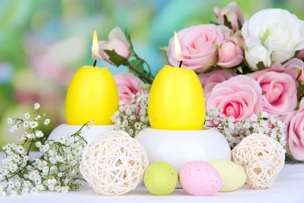 Velas de Páscoa com flores em fundo brilhante — Fotografia de Stock