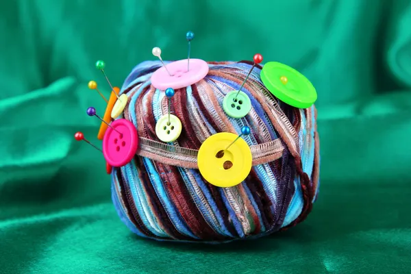 Kleurrijke knoppen en multicolor wol ballen, op weefsel achtergrondkleur — Stockfoto