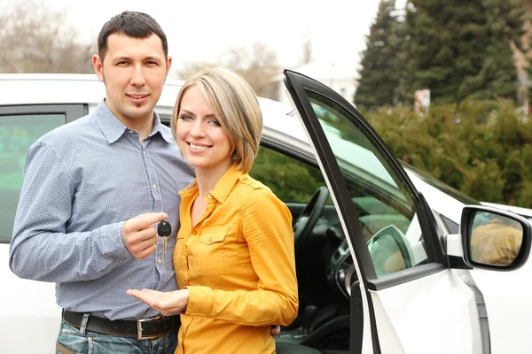 Retrato de casal bonito feliz com chaves de carro, de pé perto do carro — Fotografia de Stock