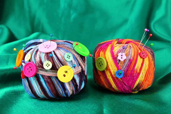 Bottoni colorati e palline di lana multicolore, su sfondo tessuto a colori — Foto Stock