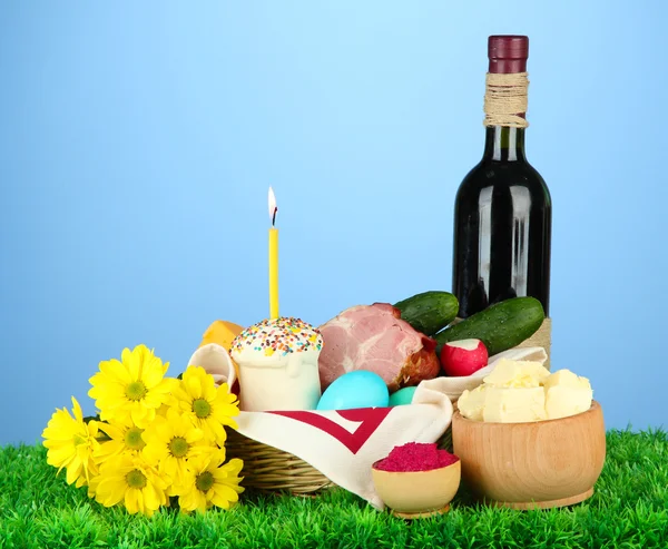 Easter basket: Conceptual photo of traditional easter food in wicker basket, on green grass, on color background — Stock Image Easter basket: Conceptual photo of traditional easter food in wicker basket, on green grass, on color background Royalty Free Stock Photos