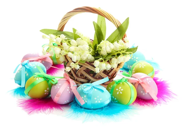 Hermosos huevos de Pascua y lirios del valle en cesta, aislados en blanco — Foto de Stock