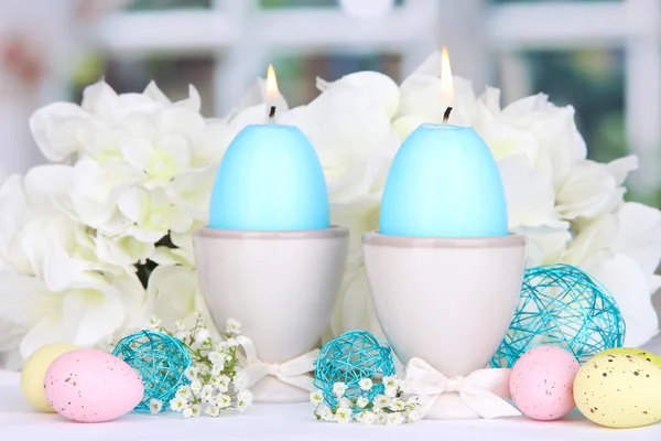 Velas de Pascua con flores en el fondo de la ventana — Foto de Stock