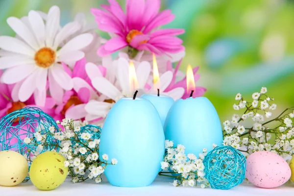 Velas de Pascua con flores sobre fondo brillante — Foto de Stock