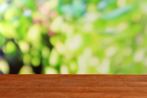 Houten tafel op helder groene achtergrond — Stockfoto