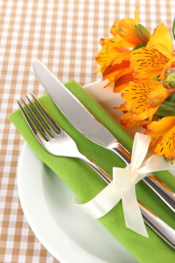 Damalı zemin üzerine çiçekli şenlikli yemek masası ayarı