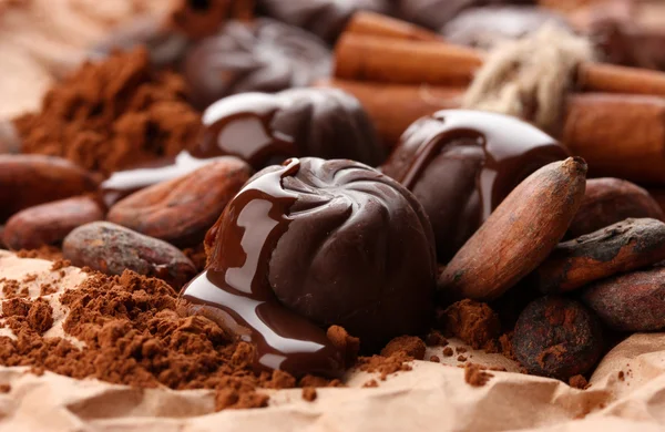 Composizione di caramelle al cioccolato, cacao e spezie su fondo marrone — Foto Stock