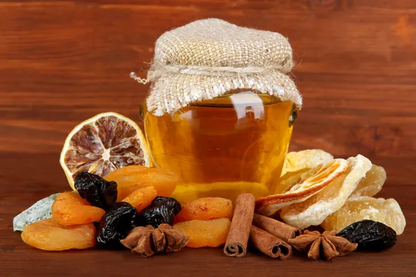 Burk honung och torkad frukt på trä bakgrund — Stockfoto