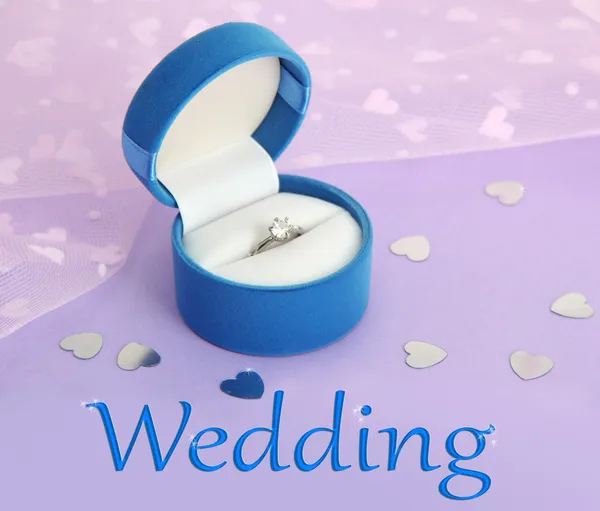 Krásná krabice se snubním prstenem na fialovém pozadí — Stock fotografie