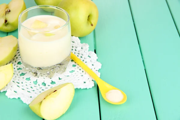 Delicious yogurt in glass with apple on wooden table close-up — Stock Photo, Image