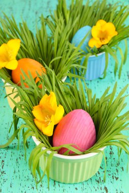 Paskalya yumurtaları kase çim yeşil ahşap masa ile yakın çekim