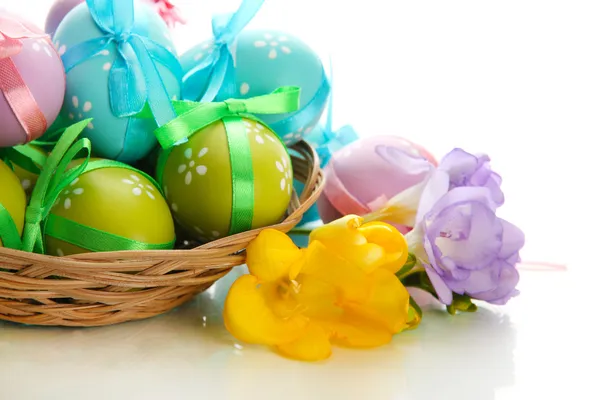 Sepette, üzerinde beyaz izole yay ile parlak Paskalya yumurtaları — Stok fotoğraf
