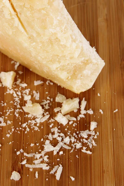 Pezzo di parmigiano su tavola di legno primo piano — Foto Stock