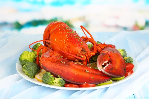 Red lobster on platter with vegetables on table close-up — Stock Photo, Image