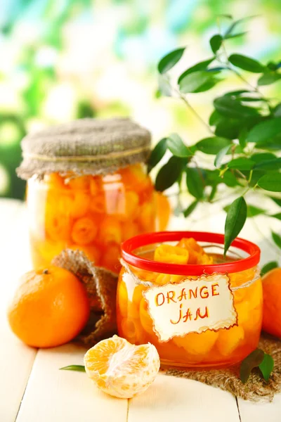 Confiture d'orange avec zeste et mandarines, sur table en bois blanc — Photo