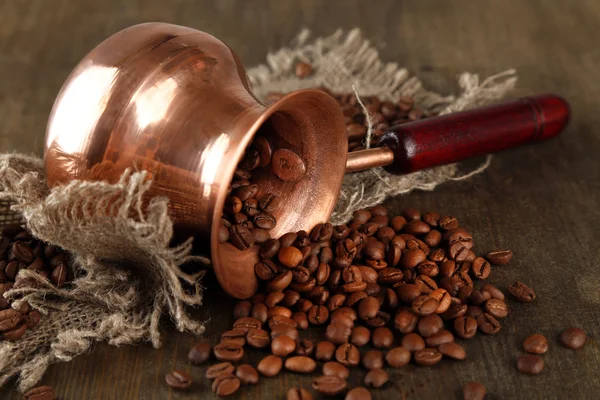 Cafetera con granos de café sobre fondo de madera — Foto de Stock