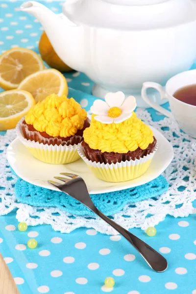 Beautiful lemon cupcakes and flavored tea on dining table close-up — Stock Photo, Image