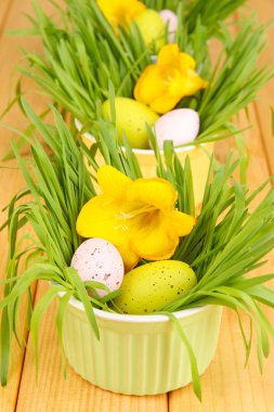 Paskalya yumurtaları kase çim üzerinde ahşap masa ile yakın çekim