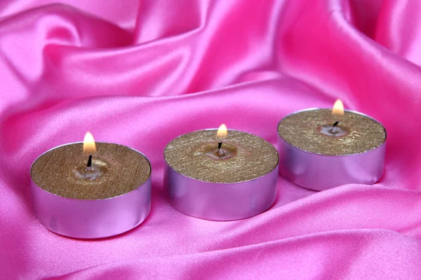 Свечи на фиолетовой ткани крупным планом — стоковое фото