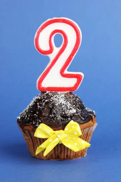 Birthday cupcake with chocolate frosting on blue background — Stock Photo, Image