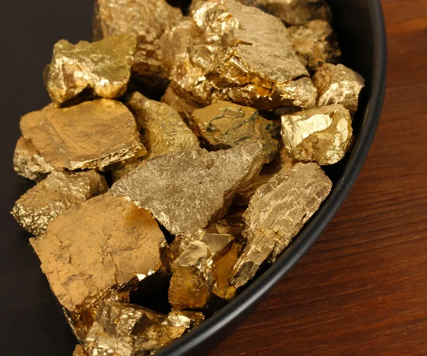 Casserole en or avec pépites d'or à l'intérieur sur fond en bois — Photo