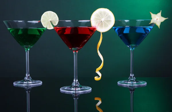 Alcoholic cocktails in martini glasses on dark green background — Stock Photo, Image