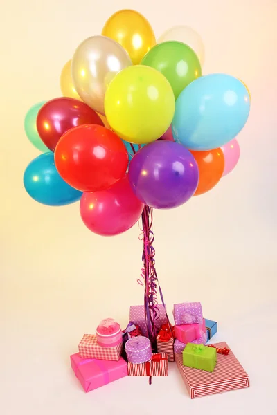 Many bright balloons and many gifts on light background — Stock Photo, Image