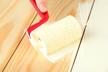 rulo fırça ahşap zemin üzerinde beyaz boya ile boyayın.