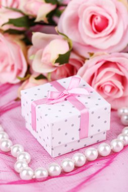 pembe kumaş üzerine gül ve hediye kutusu