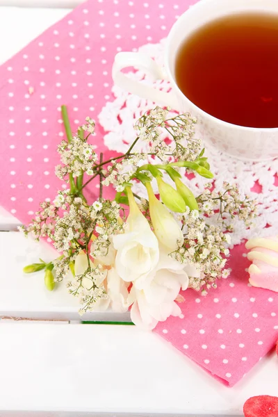 Mooie compositie met kop van thee en bloemen op houten picknick tafel close-up — Stockfoto
