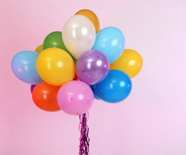 Viele helle Luftballons auf rosa Hintergrund — Stockfoto