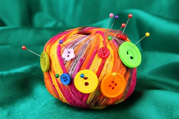 Colorful buttons and multicolor wool ball on color fabric background — Stock Photo, Image