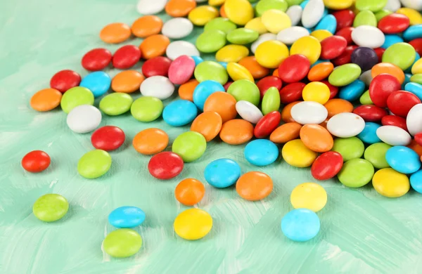 Kolorowe cukierki na zielonym tle — Zdjęcie stockowe