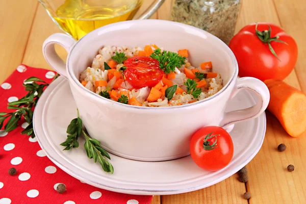 Köstlicher Reis mit Gemüse und Kräutern im Topf auf Holztisch in Großaufnahme — Stockfoto