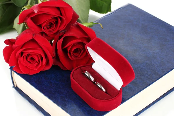 Obrączki ślubne z róż na Biblii na białym tle — Zdjęcie stockowe