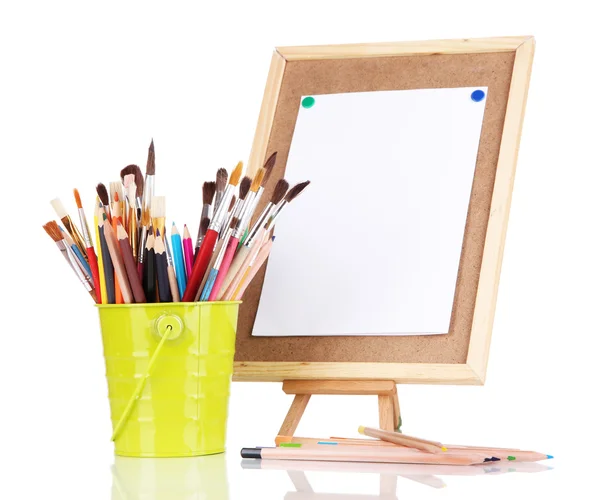 Small easel with sheet of paper with art supplies isolated on white — Zdjęcie stockowe