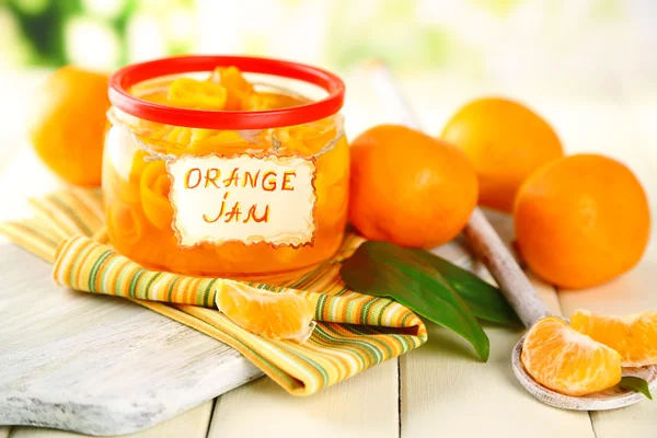 Orangenmarmelade mit Schale und Mandarinen, auf weißem Holztisch — Stockfoto