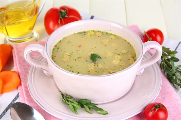 Nourishing soup in pink pan on wooden table close-up — Stock Photo, Image