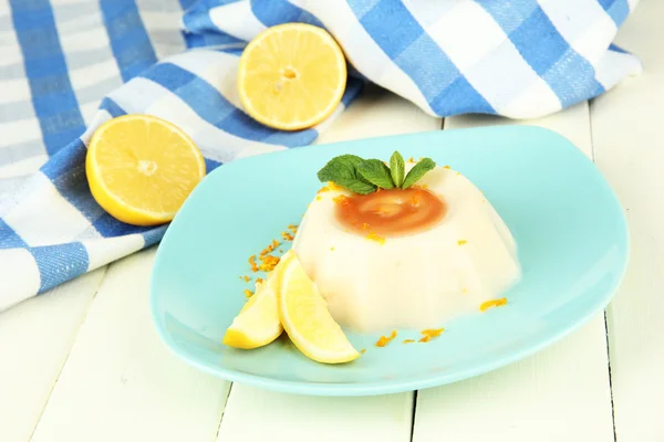 Citroen panna cotta met oranje schil en karamel saus, op een houten achtergrond kleur — Stockfoto