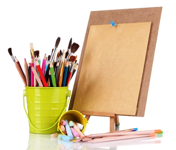 Small easel with sheet of paper with art supplies isolated on white — Stock Photo, Image